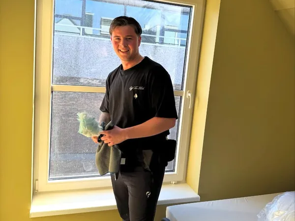Teamlid van Blink Schoonmaak bezig met ramen lappen