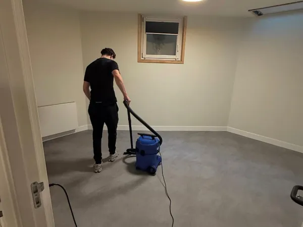 Medewerker van Blink Schoonmaak 010 aan het stofzuigen